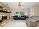 Comfortable living room boasting a stone fireplace, and natural light from a large window at 8625 Shady Glen Dr, Orlando, FL 32819