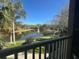 Scenic view of the lake with a water fountain from the balcony with green grass, palm trees, and lush landscaping at 8801 Villa View Cir # 207, Orlando, FL 32821