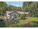 Expansive backyard featuring a well-maintained lawn, mature trees, and a charming patio area at 921 Torchwood Dr, Deland, FL 32724
