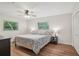 Cozy bedroom with hardwood floors, queen bed, ceiling fan, and views of nature through two windows at 921 Torchwood Dr, Deland, FL 32724