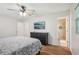 Bedroom featuring wood floors, ceiling fan, TV, and an en suite bathroom with tiled shower at 921 Torchwood Dr, Deland, FL 32724