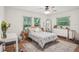 Bright bedroom with wood floors, three windows, and calming decor create a serene atmosphere at 921 Torchwood Dr, Deland, FL 32724
