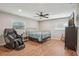 Spacious bedroom features wood floors, lots of natural light, and massage chair for comfort at 921 Torchwood Dr, Deland, FL 32724