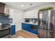 Well-equipped kitchen featuring stainless steel appliances and blue accent cabinets at 921 Torchwood Dr, Deland, FL 32724