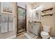 Bathroom with a tiled shower, granite vanity, and rustic floating shelves at 968 Ashton Oaks Cir, Lakeland, FL 33813