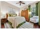 Bedroom features a queen-sized bed, wood floors, and a window that provides natural light at 968 Ashton Oaks Cir, Lakeland, FL 33813