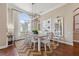 Bright dining room with large windows, wood floors, modern light fixture and seating for eight at 968 Ashton Oaks Cir, Lakeland, FL 33813