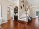 Inviting foyer with rich hardwood floors, staircase, and elegant archway leading to the kitchen at 968 Ashton Oaks Cir, Lakeland, FL 33813