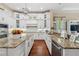 Open kitchen with a center island, granite countertops, stainless steel appliances, and bright white cabinetry at 968 Ashton Oaks Cir, Lakeland, FL 33813