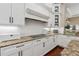 A modern kitchen with white cabinets, granite countertops, and a stylish range hood with a white backsplash at 968 Ashton Oaks Cir, Lakeland, FL 33813