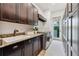 Laundry room with dark cabinets, granite countertops, stainless steel washer/dryer and door to exterior at 968 Ashton Oaks Cir, Lakeland, FL 33813