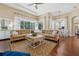 Living room with a large sectional sofa, patterned rug, hardwood floors and many windows at 968 Ashton Oaks Cir, Lakeland, FL 33813