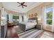 Serene main bedroom with tray ceiling, hardwood floors, and an abundance of natural light at 968 Ashton Oaks Cir, Lakeland, FL 33813