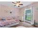 Charming pink-themed bedroom featuring a cozy bed, dresser, and natural light from the window at 986 Stonewood Ln, Maitland, FL 32751