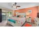 Bedroom with a sliding glass door providing outdoor views, coral accent wall, and white furniture at 986 Stonewood Ln, Maitland, FL 32751