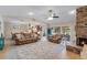 Spacious living room with a brick fireplace, tile floors, ceiling fan, and an open view of the kitchen at 986 Stonewood Ln, Maitland, FL 32751