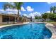 Backyard oasis featuring a sparkling blue pool, lush landscaping, and inviting patio spaces at 986 Stonewood Ln, Maitland, FL 32751
