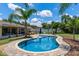 Backyard swimming pool and patio area with palm trees, sun umbrellas, and outdoor furniture at 986 Stonewood Ln, Maitland, FL 32751