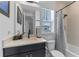 Well-lit bathroom featuring a single vanity and a bathtub with a shower at 10183 Peebles St, Orlando, FL 32827