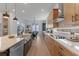 Contemporary kitchen featuring wooden cabinets, stainless steel appliances, marble countertops, and a view into the dining area at 10183 Peebles St, Orlando, FL 32827