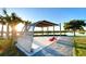 Picturesque lake view with shade structure with seating, a sidewalk, and tall grasses at 10183 Peebles St, Orlando, FL 32827