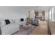 Bright living room featuring modern furniture, an area rug, and connecting to an eat-in kitchen for seamless entertaining at 10183 Peebles St, Orlando, FL 32827