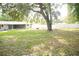 A spacious backyard featuring a large tree, white fence, and a screened-in porch at 110 N Alderwood St, Winter Springs, FL 32708