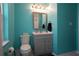 The bathroom features bright turquoise walls, a gray vanity, and gray hardware at 110 N Alderwood St, Winter Springs, FL 32708