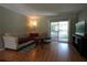 The living room has wood-look floors, a large beige couch, and a sliding glass door to the screened-in porch at 110 N Alderwood St, Winter Springs, FL 32708