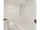 Bathroom featuring a sleek, walk-in shower with white tiling, a toilet, and white walls at 1122 Washington Ave # 7, Winter Park, FL 32789