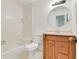 Bathroom with a wooden vanity, tub with white tile surround, and a toilet with a white seat at 1122 Washington Ave # 7, Winter Park, FL 32789