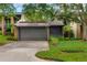 Charming home featuring a two-car garage with lush landscaping and mature trees enhancing its curb appeal at 1122 Washington Ave # 7, Winter Park, FL 32789
