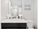 Bright bathroom with a single sink, black vanity, shower, and toilet at 1128 Challenge Dr, Davenport, FL 33896