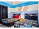 Themed bedroom featuring twin beds, Star Wars decor, and colorful bedding, creating a fun space at 1128 Challenge Dr, Davenport, FL 33896