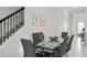 Stylish dining room with a glass-topped table, modern chairs, and a view of the staircase at 1128 Challenge Dr, Davenport, FL 33896
