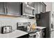 Contemporary kitchen with stainless steel appliances, sleek black cabinetry, and bright countertops at 1128 Challenge Dr, Davenport, FL 33896