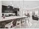 Modern kitchen with stainless steel appliances, dark cabinets, island with seating, and an open concept to the living area at 1128 Challenge Dr, Davenport, FL 33896