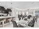 Bright living area with modern kitchen, glass dining table, and comfortable seating area featuring a foosball table at 1128 Challenge Dr, Davenport, FL 33896