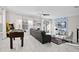 Open living room with foosball and arcade games, a leather sofa, a ceiling fan, and light-filled windows with white curtains at 1128 Challenge Dr, Davenport, FL 33896