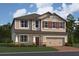 Inviting two-story home with a neutral color palette, red shutters, and an attached two-car garage at 1153 Basalt Ln, Sanford, FL 32771