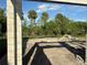 Image of backyard view of construction featuring a frame, sandy lot and greenery, and tropical trees in the distance at 1153 Basalt Ln, Sanford, FL 32771