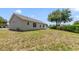 Spacious backyard with lawn, shrubbery and a large tree providing ample shade at 1243 Tangerine Cir, Lady Lake, FL 32159