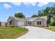 Charming single-story home with well-manicured lawn, two-car garage, awning accents, and inviting curb appeal at 1243 Tangerine Cir, Lady Lake, FL 32159