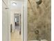 A tiled shower with a showerhead in a renovated bathroom with tiled floors at 136 Triplet Lake Dr, Casselberry, FL 32707