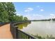 Scenic view of a wooden boardwalk extending over a calm lake under a bright, partly cloudy sky at 136 Triplet Lake Dr, Casselberry, FL 32707