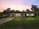 Charming single-story home with a well-manicured lawn, carport, and vibrant blue front door at 136 Triplet Lake Dr, Casselberry, FL 32707