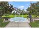 A beautiful mosaic fountain with benches in a landscaped area with mature trees and manicured lawn at 136 Triplet Lake Dr, Casselberry, FL 32707