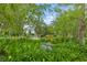 Lush green landscaping in a community park area with a bench and mature trees at 136 Triplet Lake Dr, Casselberry, FL 32707