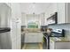 Modern kitchen with stainless steel appliances, granite countertops, and ample cabinet space at 136 Triplet Lake Dr, Casselberry, FL 32707