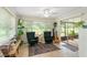 Cozy sunroom featuring two chairs, a guitar, and plenty of natural light from the large windows at 136 Triplet Lake Dr, Casselberry, FL 32707